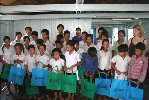 The children with Syed Hussain (back), Padma da Silva and Carol Bennetto (right).  The children are holding green and blue bags with their prizes in
